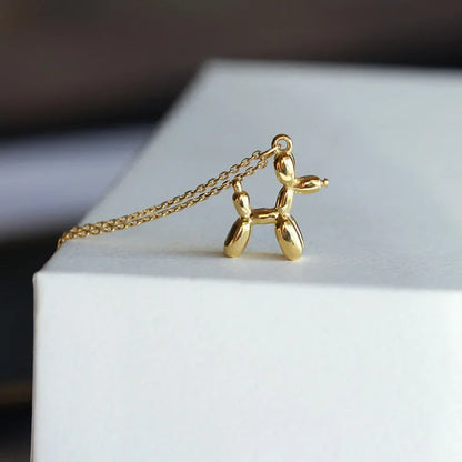 Gold-colored necklace with balloon dog pendant